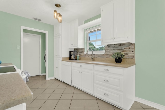 8811 Pheasant Dr, Chandler, TX 75758 - kitchen featuring white dishwasher, a sink, decorative backsplash, and light countertops