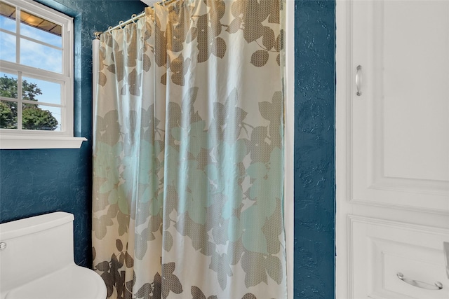 8811 Pheasant Dr, Chandler, TX 75758 - full bath featuring a textured wall, toilet, and a shower with shower curtain