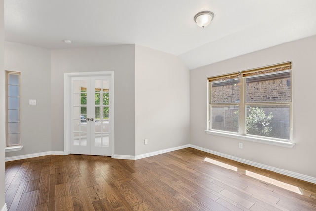 409 Bird Creek Dr, Little Elm, TX 75068 - unfurnished room featuring baseboards, wood finished floors, french doors, vaulted ceiling, and a smoke detector