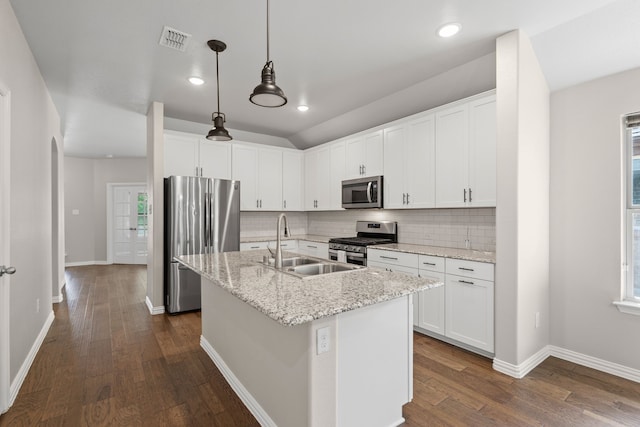 409 Bird Creek Dr, Little Elm, TX 75068 - kitchen featuring stainless steel appliances, a sink, dark wood-type flooring, tasteful backsplash, and a kitchen island with sink