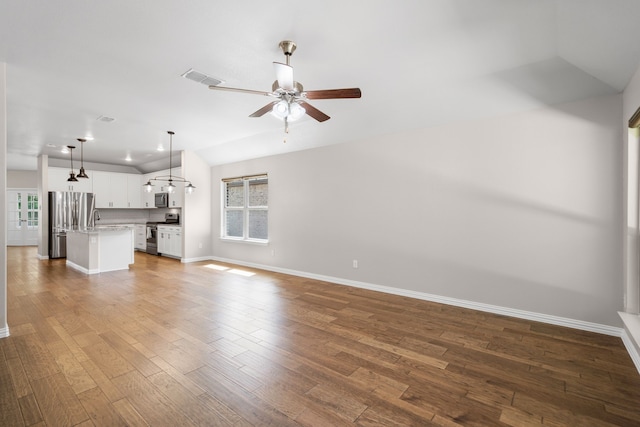 409 Bird Creek Dr, Little Elm, TX 75068 - unfurnished living room featuring ceiling fan, baseboards, wood finished floors, and vaulted ceiling