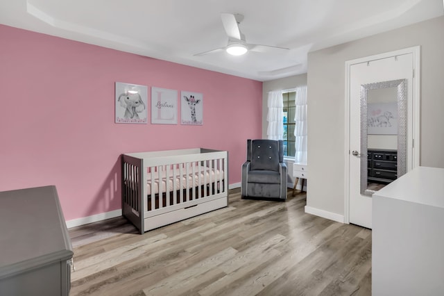 7108 Bermuda Ct, North Richland Hills, TX 76180 - bedroom with wood finished floors, baseboards, a nursery area, and ceiling fan