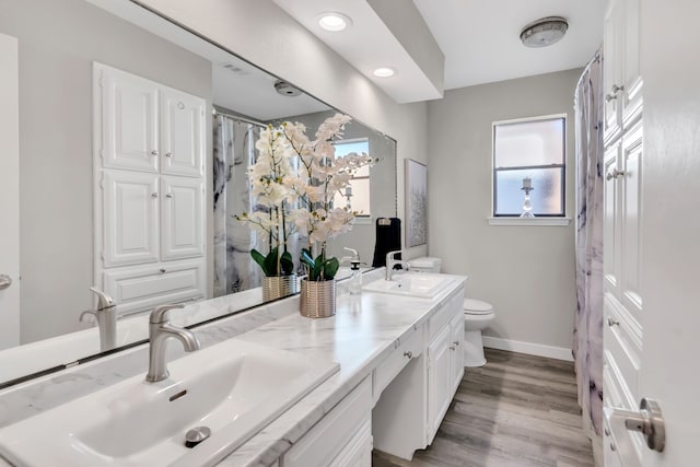 7108 Bermuda Ct, North Richland Hills, TX 76180 - full bathroom featuring double vanity, toilet, baseboards, wood finished floors, and a shower with curtain