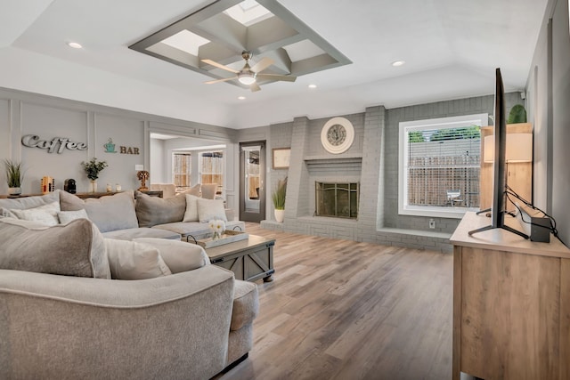 7108 Bermuda Ct, North Richland Hills, TX 76180 - living area featuring wood finished floors, a ceiling fan, a brick fireplace, recessed lighting, and a skylight