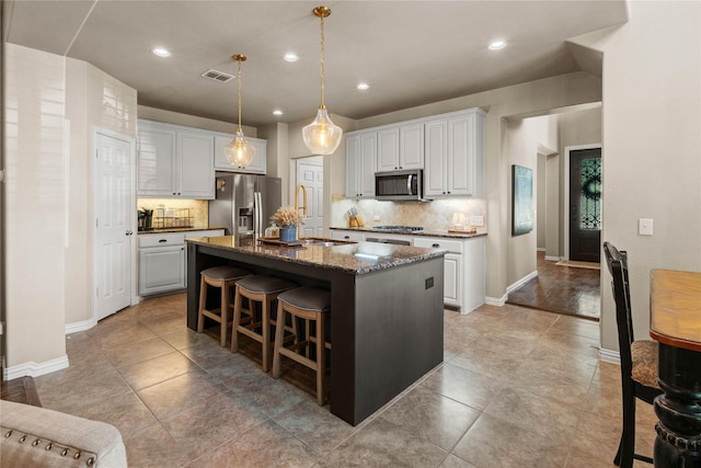 1704 Landon Ln, Mckinney, TX 75071 - kitchen with appliances with stainless steel finishes, a sink, tasteful backsplash, a kitchen island with sink, and a breakfast bar area