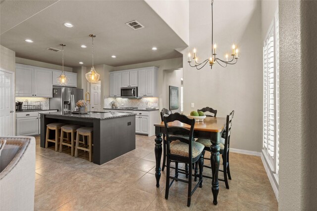 1704 Landon Ln, Mckinney, TX 75071 - kitchen with appliances with stainless steel finishes, backsplash, a chandelier, a kitchen bar, and recessed lighting
