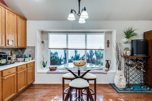 1699 Garrison Dr, Frisco, TX 75033 - dining area with wood finished floors, a chandelier, and baseboards