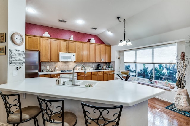 1699 Garrison Dr, Frisco, TX 75033 - kitchen featuring stainless steel fridge, white microwave, a sink, light countertops, and light wood-style floors
