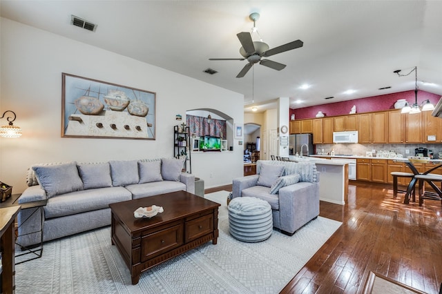 1699 Garrison Dr, Frisco, TX 75033 - living area featuring a ceiling fan, dark wood-style floors, arched walkways, a chandelier, and lofted ceiling