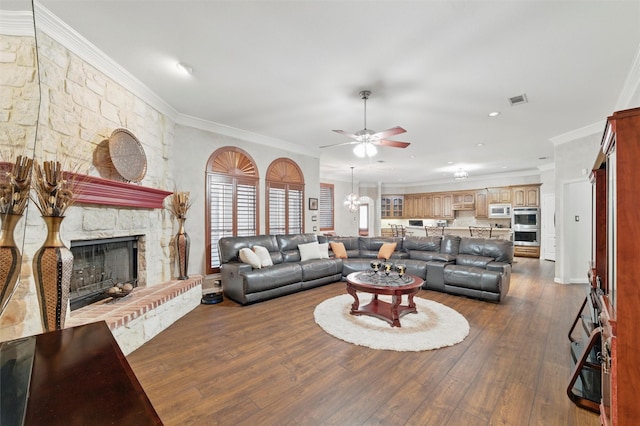 811 Shady Bend Dr, Kennedale, TX 76060 - living room featuring ceiling fan, a stone fireplace, dark wood finished floors, ornamental molding, and a chandelier
