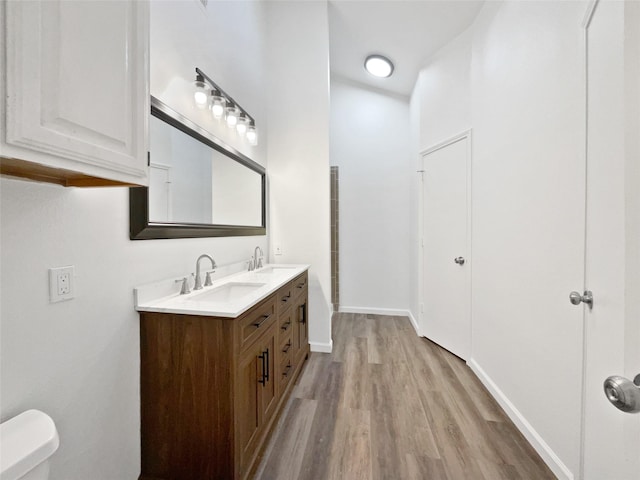 5205 Foley Dr, Arlington, TX 76013 - bathroom with wood finished floors, toilet, double vanity, and baseboards