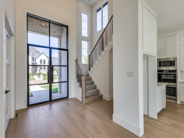 1045 Bent Tree Ln, Gunter, TX 75058 - foyer with light wood-type flooring, stairs, baseboards, and a high ceiling