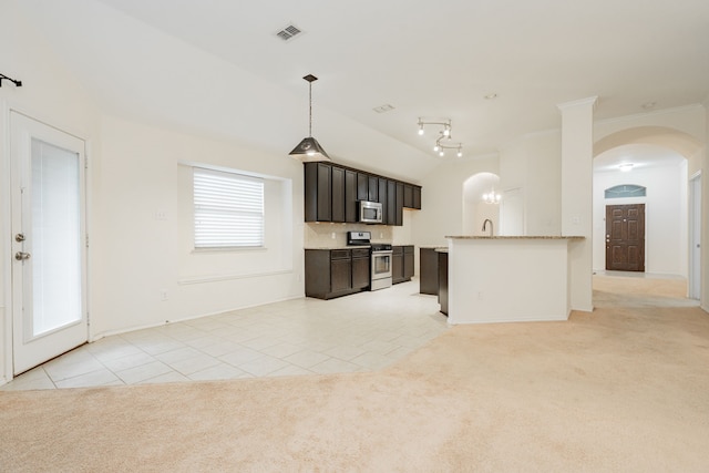 127 Wandering Dr, Forney, TX 75126 - kitchen with appliances with stainless steel finishes, light tile patterned floors, arched walkways, light carpet, and pendant lighting