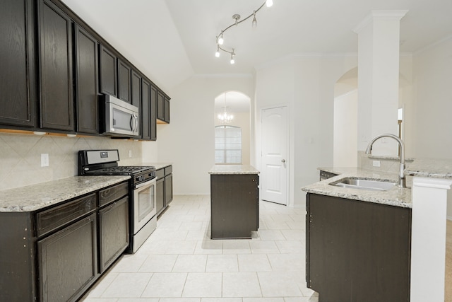 127 Wandering Dr, Forney, TX 75126 - kitchen with appliances with stainless steel finishes, a sink, arched walkways, ornamental molding, and a center island