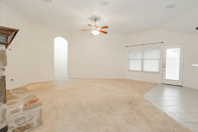 127 Wandering Dr, Forney, TX 75126 - unfurnished living room featuring a ceiling fan, arched walkways, tile patterned floors, carpet floors, and ornamental molding