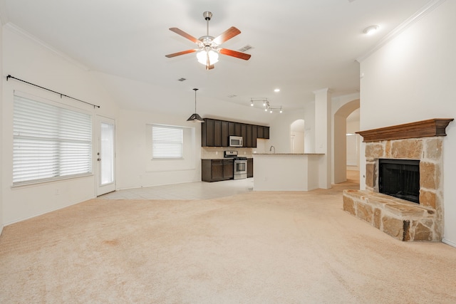 127 Wandering Dr, Forney, TX 75126 - unfurnished living room with arched walkways, ceiling fan, light carpet, a fireplace, and ornamental molding