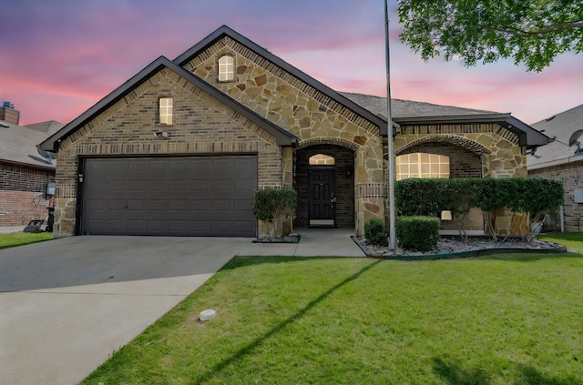 127 Wandering Dr, Forney, TX 75126 - french country style house with an attached garage, stone siding, concrete driveway, a front lawn, and brick siding