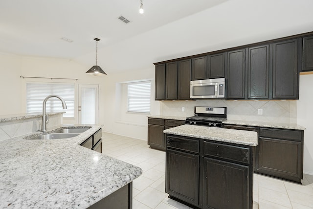 127 Wandering Dr, Forney, TX 75126 - kitchen featuring stainless steel appliances, a sink, vaulted ceiling, a kitchen island, and light tile patterned flooring
