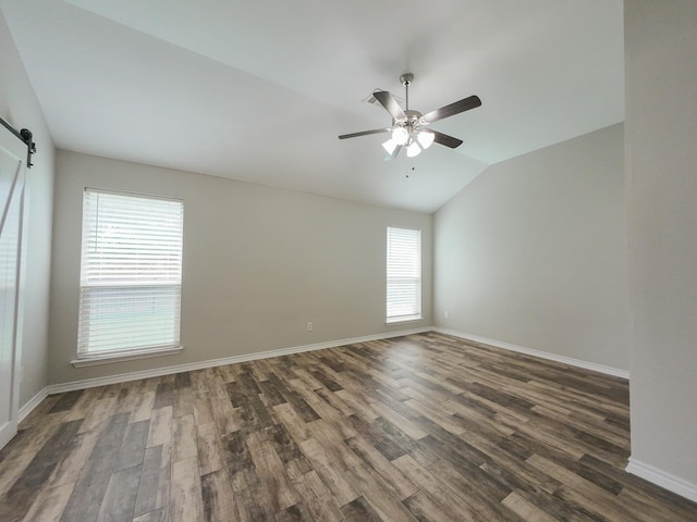 204 Spring Hollow Dr, Saginaw, TX 76131 - spare room with lofted ceiling, dark wood-type flooring, ceiling fan, a barn door, and baseboards