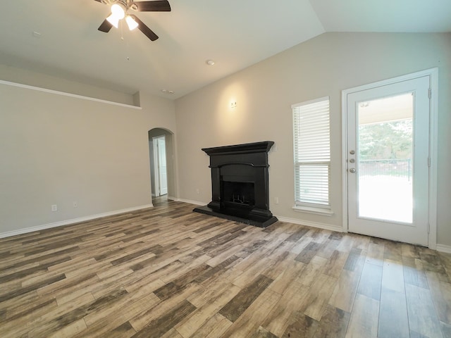204 Spring Hollow Dr, Saginaw, TX 76131 - unfurnished living room featuring arched walkways, a ceiling fan, vaulted ceiling, and wood finished floors