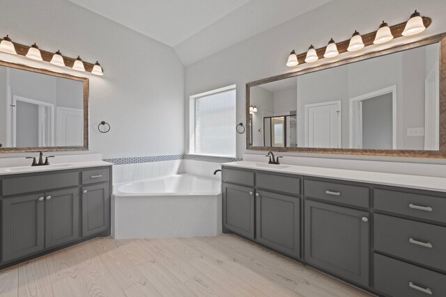 1038 Mickelson Dr, Granbury, TX 76048 - full bath featuring a bath, two vanities, lofted ceiling, wood finished floors, and a stall shower