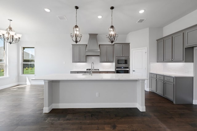 1038 Mickelson Dr, Granbury, TX 76048 - kitchen featuring stainless steel appliances, gray cabinets, premium range hood, a chandelier, and an island with sink