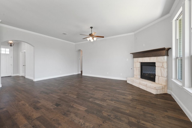 1038 Mickelson Dr, Granbury, TX 76048 - unfurnished living room featuring arched walkways, a ceiling fan, a fireplace, crown molding, and baseboards