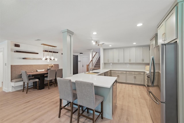 801 Edgefield Rd, Fort Worth, TX 76107 - kitchen featuring freestanding refrigerator, a breakfast bar, light wood finished floors, a sink, and recessed lighting