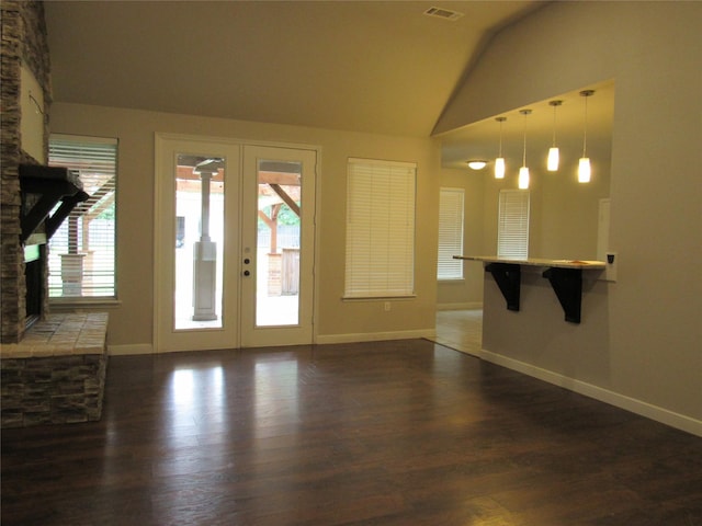 2817 Henry Rd, Lancaster, TX 75134 - unfurnished living room with french doors, a fireplace, vaulted ceiling, plenty of natural light, and baseboards