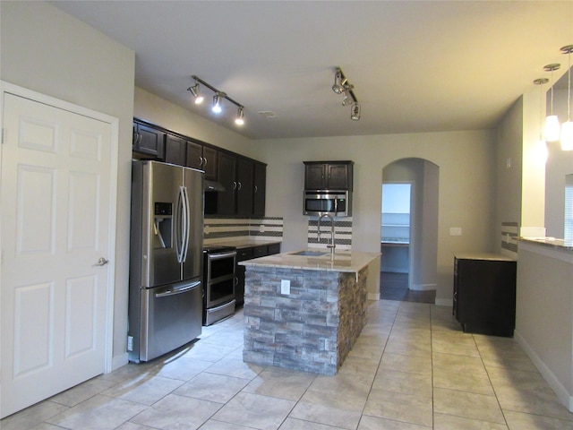 2817 Henry Rd, Lancaster, TX 75134 - kitchen with stainless steel appliances, a sink, arched walkways, and light tile patterned floors