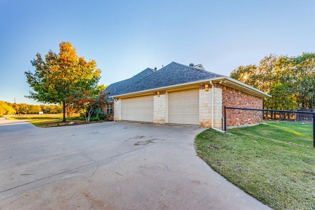6306 Shadow Valley Dr, Burleson, TX 76028 - view of side of property featuring a lawn, concrete driveway, a shingled roof, stone siding, and a garage