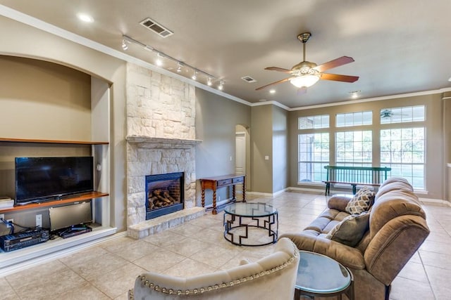 6306 Shadow Valley Dr, Burleson, TX 76028 - living room featuring tile patterned flooring, crown molding, track lighting, arched walkways, and ceiling fan