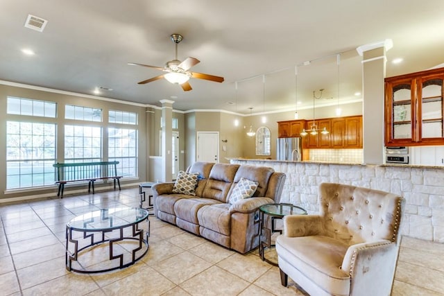 6306 Shadow Valley Dr, Burleson, TX 76028 - living area featuring light tile patterned flooring, ornamental molding, a ceiling fan, and ornate columns