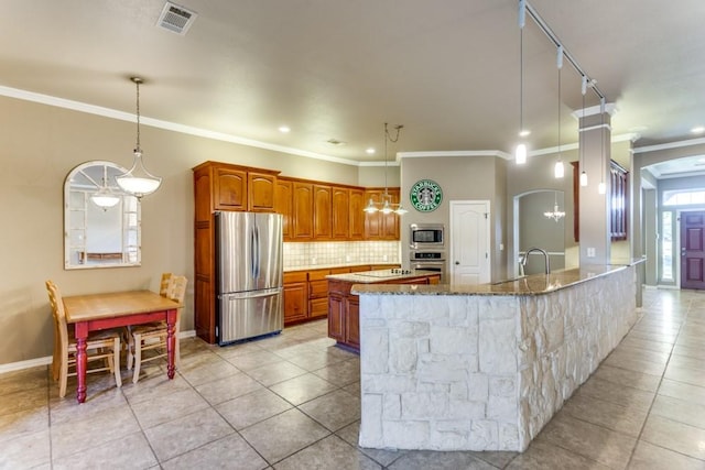 6306 Shadow Valley Dr, Burleson, TX 76028 - kitchen with appliances with stainless steel finishes, light tile patterned floors, stone countertops, backsplash, and brown cabinetry