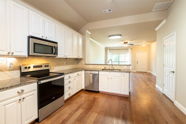 3075 Willow Grove Blvd Unit 1105, Mckinney, TX 75070 - kitchen featuring appliances with stainless steel finishes, a peninsula, light wood finished floors, backsplash, and white cabinets