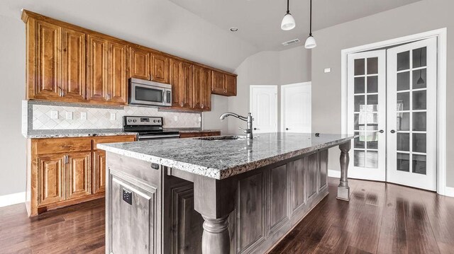 4907 Lakepark Dr, Sanger, TX 76266 - kitchen featuring stainless steel appliances, a sink, brown cabinets, light stone countertops, and lofted ceiling
