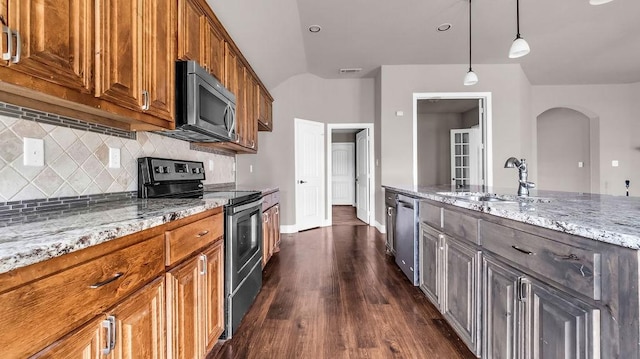 4907 Lakepark Dr, Sanger, TX 76266 - kitchen featuring stainless steel appliances, a sink, arched walkways, light stone counters, and decorative backsplash