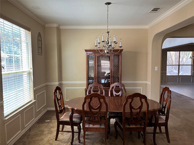 1435 Delta Dr, Cedar Hill, TX 75104 - carpeted dining space with a chandelier, a decorative wall, plenty of natural light, ornamental molding, and arched walkways