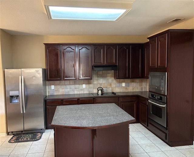 1435 Delta Dr, Cedar Hill, TX 75104 - kitchen with stainless steel appliances, light tile patterned floors, backsplash, dark brown cabinetry, and a kitchen island