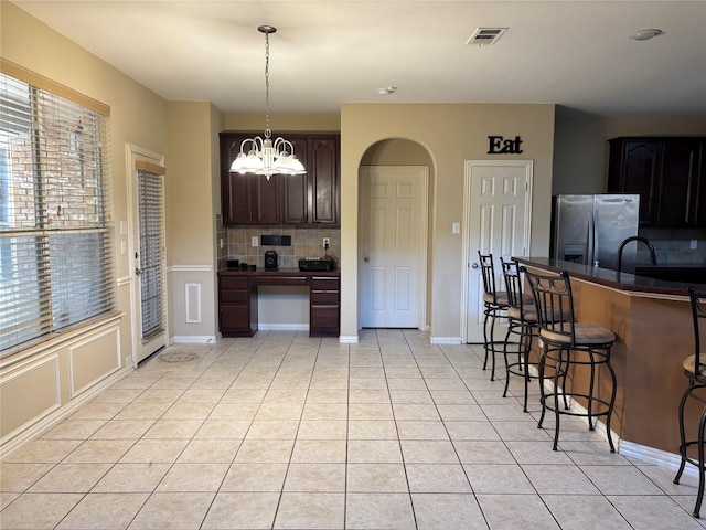 1435 Delta Dr, Cedar Hill, TX 75104 - kitchen with stainless steel fridge, tasteful backsplash, a chandelier, and dark countertops