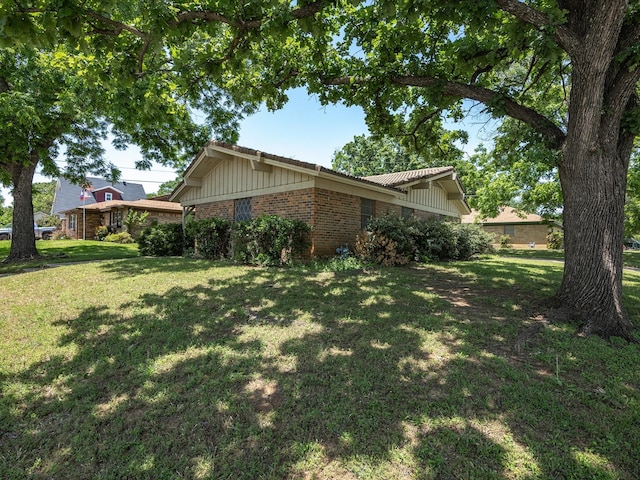 view of home's exterior featuring brick siding, board and batten siding, and a lawn