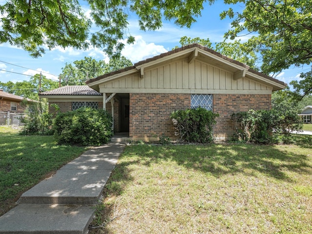 ranch-style house with brick siding and a front lawn