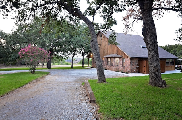 701 Elmhill Blvd, Burleson, TX 76028 - view of home's exterior with a yard, curved driveway, brick siding, and roof with shingles