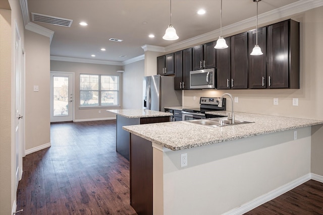 101 Springtree St, Denton, TX 76209 - kitchen featuring stainless steel appliances, a center island, dark wood finished floors, a sink, and crown molding