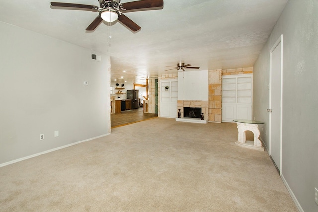 10578 High Hollows Dr Unit 269, Dallas, TX 75230 - unfurnished living room featuring ceiling fan, carpet, baseboards, and a fireplace with raised hearth