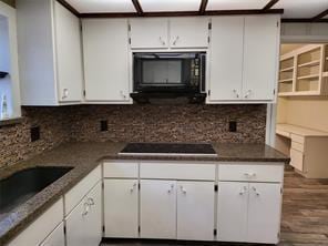5728 Rockhill Rd, Fort Worth, TX 76112 - kitchen featuring black appliances, dark wood-type flooring, decorative backsplash, white cabinetry, and dark countertops