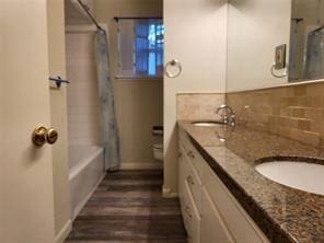 5728 Rockhill Rd, Fort Worth, TX 76112 - full bath with shower / tub combo, wood finished floors, double vanity, toilet, and baseboards