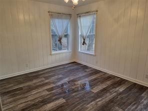 5728 Rockhill Rd, Fort Worth, TX 76112 - unfurnished room featuring dark wood-style floors, plenty of natural light, and wood walls