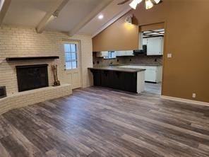 5728 Rockhill Rd, Fort Worth, TX 76112 - unfurnished living room with wood finished floors, a brick fireplace, a ceiling fan, and baseboards