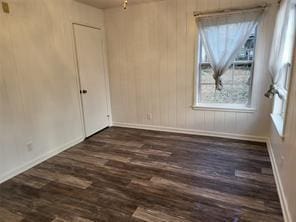 5728 Rockhill Rd, Fort Worth, TX 76112 - unfurnished room with dark wood finished floors, baseboards, and wood walls